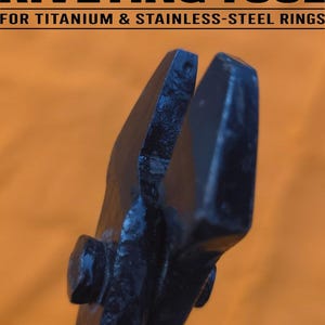 May include: A heavy-duty riveting tool for titanium and stainless-steel rings. The black tool has a riveted joint and is set against an orange background. The text "RIVETING TOOL" is visible.