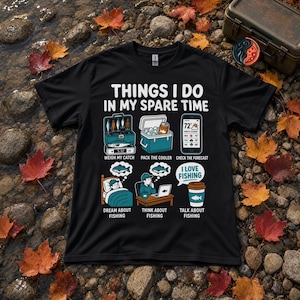 May include: A black t-shirt featuring the white text "THINGS I DO IN MY SPARE TIME" above six illustrations: weighing a catch, packing a cooler, checking a weather forecast, dreaming about fishing, thinking about fishing, and talking about fishing.