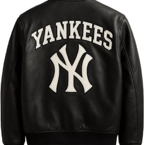 Può includere: Una giacca varsity in pelle nera con la scritta YANKEES in lettere bianche arcuata sopra il logo bianco intrecciato NY dei New York Yankees sul retro. La giacca presenta un colletto, polsini e orlo a coste di colore nero.