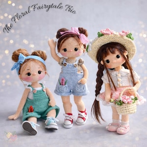 Puede incluir: Tres muñecas de ganchillo, cada una con un atuendo y peinado únicos. Las muñecas visten monos, vestidos y sombreros, y sostienen cestas. El texto "The Floral Fairytale Trio" está escrito en cursiva en la parte superior de la imagen.