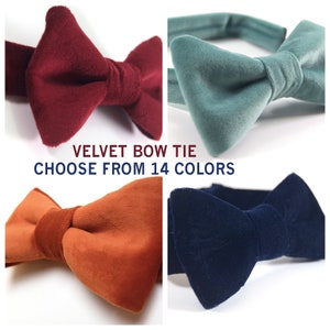 Op de afbeelding: Vier fluwelen strikjes in verschillende kleuren: bordeauxrood, teal, gebrande sinaasappel en donkerblauw. De tekst "VELVET BOW TIE CHOOSE FROM 14 COLORS" wordt onder de strikjes weergegeven.