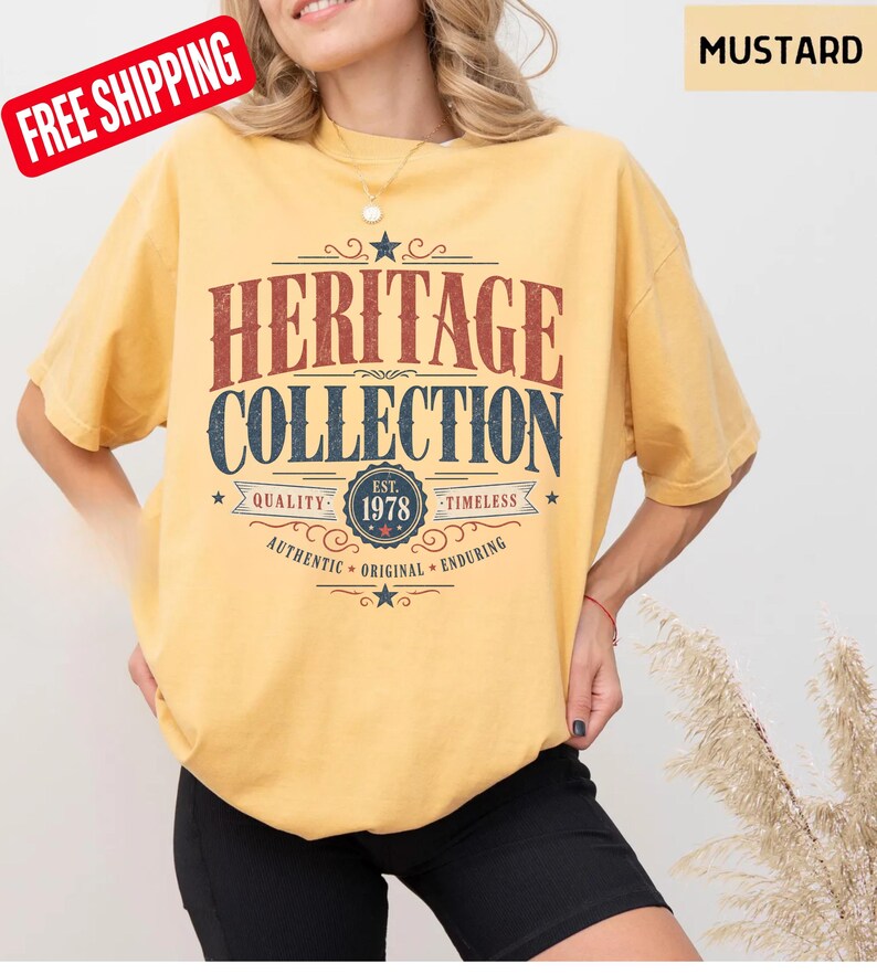 May include: Mustard-coloured t-shirt with the text "HERITAGE COLLECTION" in red and blue. The shirt features a vintage design with the year "1978" and the words "QUALITY", "TIMELESS", "AUTHENTIC", "ORIGINAL", and "ENDURING".