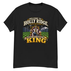 Può includere: Una t-shirt nera con una stampa grafica che riporta il testo WELCOME TO HOLLY RIDGE, LOUISIANA, WHERE DATA FARMING IS KING. Il design mostra una figura coronata seduta su un trono con uno scettro, circondata da edifici di data center e codice binario.