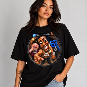 May include: A black t-shirt featuring a circular graphic of three cartoon characters: a pig in a red plaid shirt, a central figure with a gold chain labeled SAHUR, and a blue number 67 character. Above them is a notification bar reading There is motion at your front door.