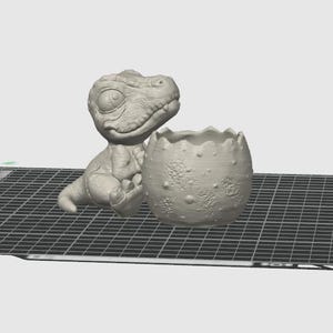 May include: A light gray 3D rendered model of a baby dinosaur sitting next to a cracked, textured eggshell container. The dinosaur has large eyes and a small snout, while the eggshell features a jagged top edge and a bumpy, uneven surface.