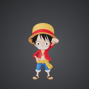 Puede incluir: Figura de un personaje de dibujos animados con un sombrero de paja amarillo con una banda roja, una chaqueta roja, pantalones cortos azules y sandalias. El personaje tiene el pelo negro y está haciendo un puño con una mano.