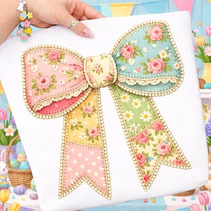 May include: A decorative bow with a patchwork design featuring floral patterns and lace trim. The bow has sections of pink, yellow, green, and blue fabric, each adorned with roses and daisies. The edges are outlined with a beaded trim.