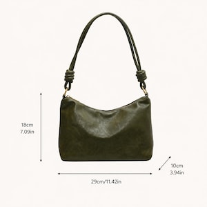 Pu&ograve; includere: Borsa a tracolla verde oliva con dettaglio a nodo sul cinturino. La borsa misura 29 cm di lunghezza, 18 cm di altezza e 10 cm di larghezza. Presenta una chiusura con cerniera e un design semplice ed elegante.