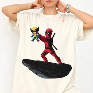 Unleash your inner anti-hero with this bold and playful Deadpool & Wolverine mashup T-Shirt! 🖤🔥 Combining the chaotic humor of Deadpool with the fierce energy of Wolverine, this design delivers a fun twist—perfectly blended with a nostalgic nod to The Lion King theme. 🦁✨