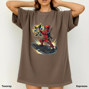Puede incluir: Camiseta color espresso con un dise&ntilde;o de Deadpool y Lobezno. Deadpool viste un traje rojo y negro, empu&ntilde;ando una espada, y Lobezno un traje amarillo y azul. La camiseta tiene los textos "Texoray" y "Espresso".