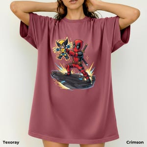 Puede incluir: Camiseta color carmes&iacute; con una ilustraci&oacute;n de dibujos animados de Deadpool y Wolverine. El gr&aacute;fico muestra a Deadpool con un traje rojo y negro con una espada, y a Wolverine con un disfraz amarillo y azul. La camiseta tiene el texto "Texoray" en la parte inferior.