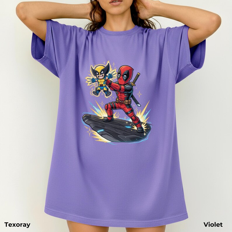 Puede incluir: Camiseta violeta con un gr&aacute;fico de Deadpool y Wolverine. Deadpool, con un traje rojo y negro, sostiene una espada y est&aacute; de pie sobre una roca negra. Wolverine lleva un traje amarillo y azul. Los textos "Texoray" y "Violet" est&aacute;n abajo.