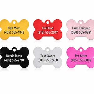 Puede incluir: Un conjunto de diez placas de identificaci&oacute;n para mascotas con forma de hueso en varios colores, incluyendo azul, amarillo, rojo, rosa, verde, negro, blanco y magenta. Cada placa tiene un peque&ntilde;o orificio para colgar y texto negro.