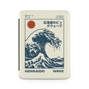 Könnte beinhalten: Cremefarbene Handyhülle mit einer stilisierten Illustration einer großen ozeanischen Welle in Marineblau und einer roten Sonne. Der Text "HOKKAIDO WAVE" ist unten aufgedruckt. Japanischer Text ist ebenfalls vorhanden. Schwarzer Rand.