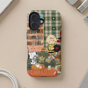 Peanuts characters Charlie Brown and Snoopy are on a phone case with a bookshelf.