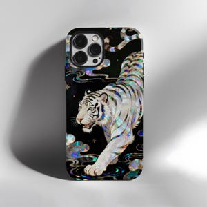 May include: Black phone case with a white tiger design and iridescent details. The tiger is shown walking with an artistic style. The case has a glossy finish and a protective design.
