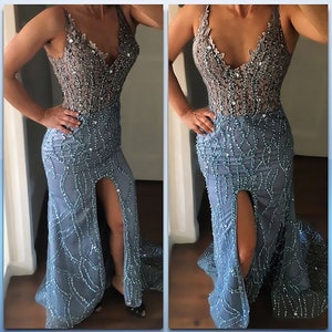 Model wearing a custom-made light blue evening gown with a beaded bodice, deep V-neckline, and intricate beadwork on a fitted skirt featuring a thigh-high slit