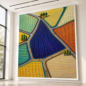Könnte beinhalten: Ein großes rechteckiges Wandgemälde, das eine Luftaufnahme von landwirtschaftlichen Feldern in leuchtenden Farben wie Tiefblau, Gelb, Orange und Grün zeigt. Die Landschaft besteht aus geometrischen Flächen, die durch Wege und Baumgruppen getrennt sind.