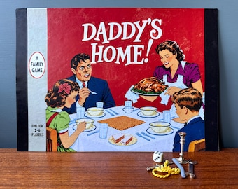 May include: A vintage board game box titled Daddy's Home! featuring a family dinner illustration, accompanied by a white die, a small metal candlestick, a yellow rope piece, a blue plastic rod, and a small metal wrench on a wooden surface.
