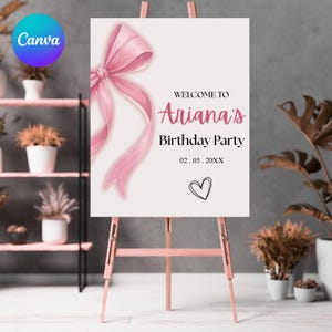 Op de afbeelding: Een roze welkomstbord voor Ariana's verjaardagsfeest, met een aquarel strik en de tekst "Welkom op Ariana's verjaardagsfeest" en een hartsymbool. Het bord staat op een houten ezel.