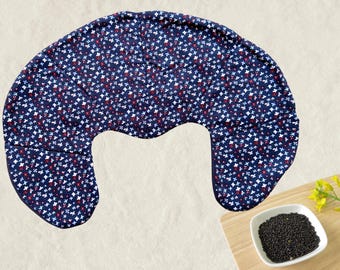 Puede incluir: Una almohada de lactancia azul marino con un estampado floral de flores blancas y rojas. La almohada tiene forma de media luna y está diseñada para la comodidad. La almohada está sobre un fondo claro.