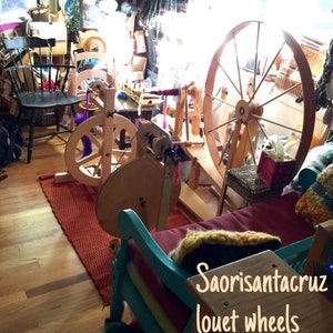 Puede incluir: Una habitaci&oacute;n llena de ruecas, cardas y fibras. La habitaci&oacute;n est&aacute; llena de luz natural y tiene un ambiente r&uacute;stico. El texto "Saorisantacruz louet wheels fibers, carders" es visible en la imagen.