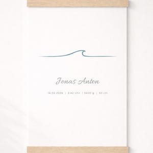 May include: A white vertical poster with a light wood magnetic frame, featuring a blue line drawing of a wave. Below the wave, the text reads Jonas Anton, followed by the date 14.02.2026, the time 3:42 Uhr, the weight 3400 g, and the length 53 cm.
