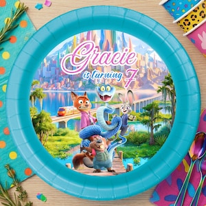 May include: A white ceramic mug with a black handle and the text "But First, Coffee" in a bold, black font. The mug is set against a blurred background, suggesting a cosy setting.