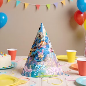 May include: A cone-shaped party hat with a cartoon design, featuring characters from an animated film. The hat has a blue and white pattern and the text "Sucie 7th Birthday". Party decorations are visible.