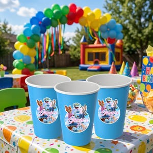 May include: A white ceramic mug with a black handle and the text "But First, Coffee" in a bold, black font. The mug is set against a blurred background. The mug appears to be approximately 10 cm tall.