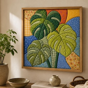 Può includere: Un'opera d'arte murale quadrata che presenta un collage in tessuto trapuntato di tre grandi foglie di monstera in tonalità di verde, su uno sfondo di toppe di tessuto colorato a motivi, il tutto racchiuso in una cornice di legno chiaro.