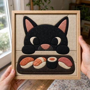 Pode incluir: Uma peça de arte de parede em tecido com moldura quadrada apresentando um gato preto com olhos grandes e orelhas cor-de-rosa espreitando sobre uma bandeja escura. A bandeja contém três peças de sushi, incluindo dois nigiris com peixe laranja e um rolo maki escuro, tudo em tecido texturizado.