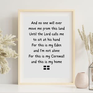 May include: A framed print with a light wood frame. The print features black text on a white background. The text reads, "And no one will ever move me from this land...For this is my Cornwall and this is my home."