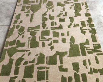 Alfombra geométrica tejida a mano: verde, arena suave, pelo alto y bajo.