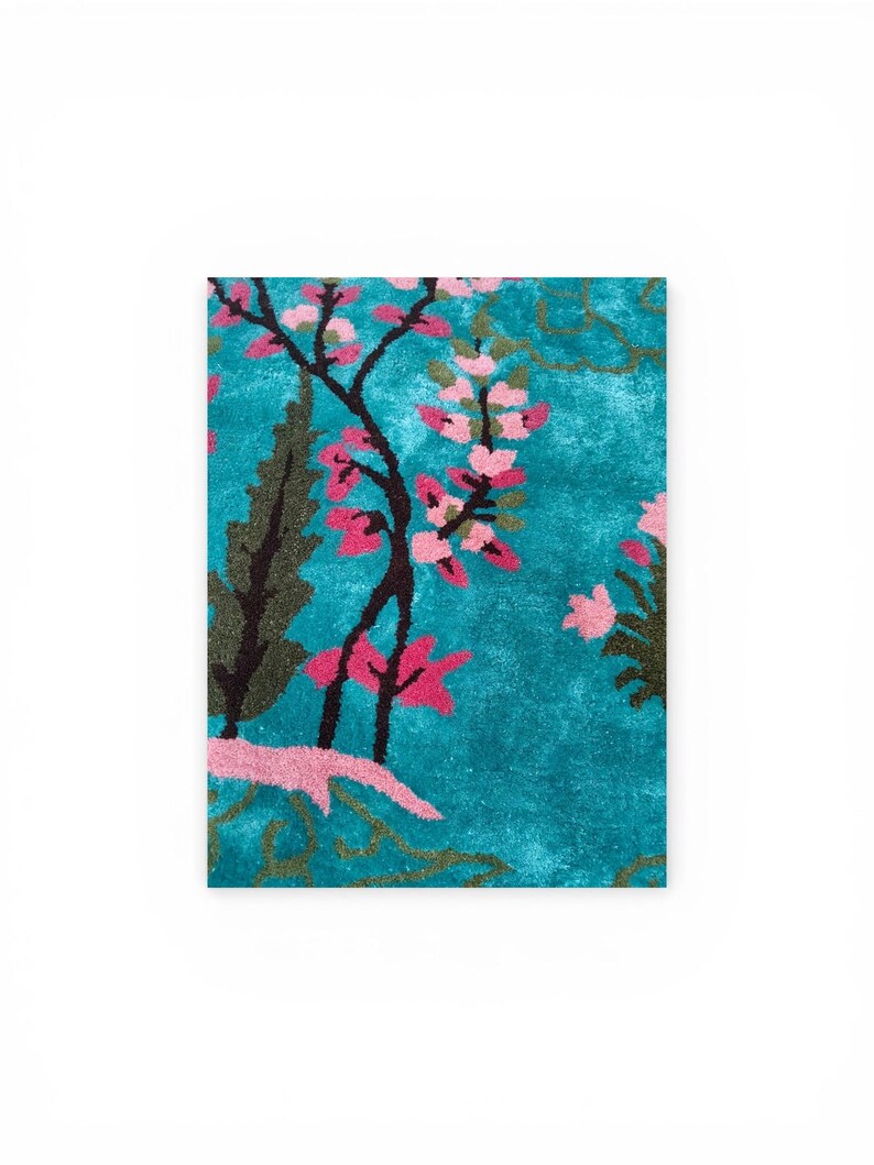 Puede incluir: Una alfombra rectangular con fondo turquesa y dise&ntilde;o floral. La alfombra presenta flores rosas y follaje verde oscuro. El dise&ntilde;o se asienta sobre un fondo turquesa texturizado, creando un aspecto vibrante y art&iacute;stico.