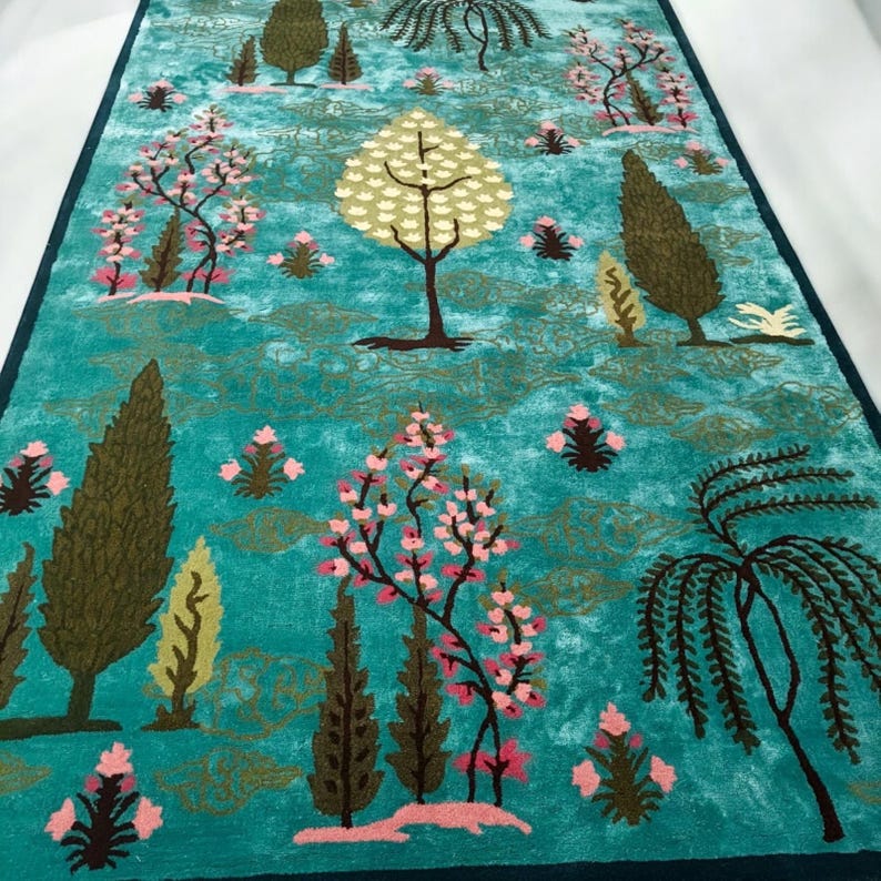 Puede incluir: Una alfombra de pasillo de color turquesa con un patr&oacute;n repetido de &aacute;rboles estilizados y elementos florales. El dise&ntilde;o presenta varios tipos de &aacute;rboles en tonos de verde, rosa y marr&oacute;n sobre un fondo turquesa. La alfombra tiene un borde azul oscuro.