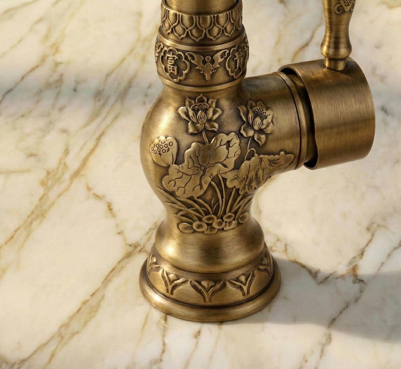 May include: Close-up of an antique brass faucet with intricate floral and oriental design. The faucet features detailed carvings of lotus flowers and leaves, with a warm, aged finish. The handle and base also have decorative patterns.