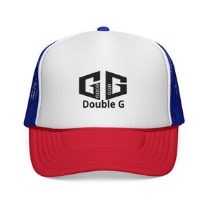 Puede incluir: Gorra de camionero roja, blanca y azul. El panel frontal es blanco, la visera es roja y la parte trasera es de malla azul. La gorra muestra el texto "GOOD GOD Double G" en negro, en un diseño geométrico.