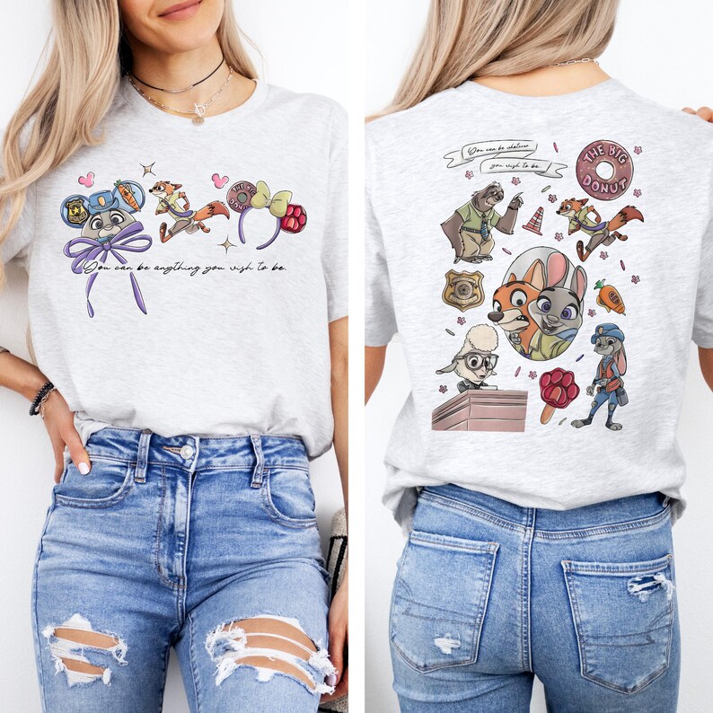 May include: A light gray t-shirt featuring Zootopia character graphics. The front displays ears, a fox, and the text You can be anything you wish to be. The back shows a collage of characters, a donut, a badge, and a carrot graphic.