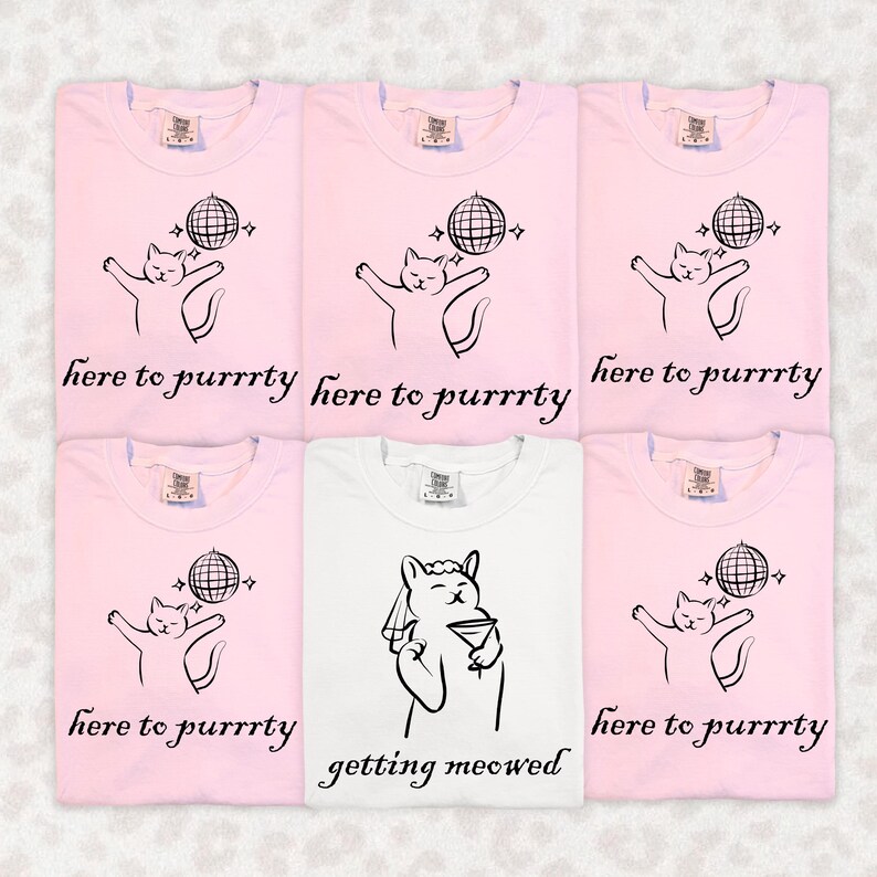 May include: Six t-shirts, five pink and one white, with cat-themed graphics. The pink shirts say "here to purrrty" with a cat and disco ball design. The white shirt says "getting meowed" with a cat holding a martini.