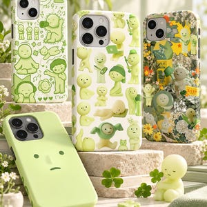 May include: Four smartphone cases featuring light green color palettes and whimsical character illustrations. One case is solid light green with a simple face, while others display various cartoon figures, floral patterns, and small text elements.