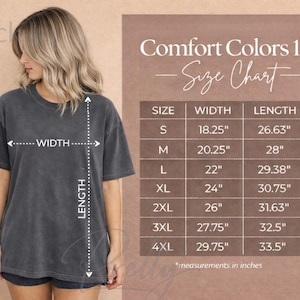 May include: A woman wearing a dark gray Comfort Colors 1717 t-shirt. The image includes a size chart with measurements in inches, detailing width and length for sizes S through 4XL. The shirt is a relaxed fit.