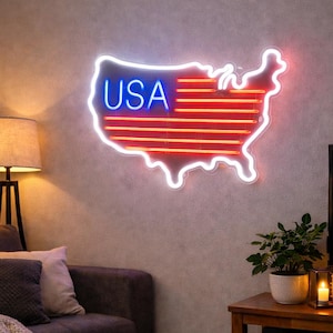 以下が含まれることがあります： アメリカ合衆国の形をしたネオンサイン。青色の「USA」の文字と赤い水平線があります。リビングルームの灰色の壁に取り付けられています。部屋にはソファ、コーヒーテーブル、テレビがあります。