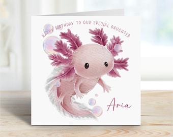 Puede incluir: Tarjeta de felicitación cuadrada con una ilustración de acuarela de un ajolote rosa con branquias y burbujas moradas. El texto "Happy Birthday to our special daughter" está encima del ajolote, y el nombre "Aria" debajo.