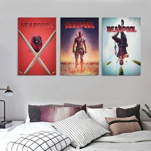 May include: Three Deadpool film posters. The first poster shows the Deadpool mask with crossed swords on a red background. The second poster shows Deadpool standing in flames. The third poster shows Deadpool upside down.