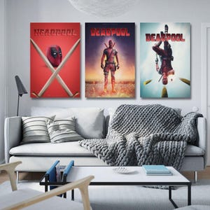 May include: A set of three Deadpool film posters. The first poster displays the Deadpool mask with crossed swords and the word "HEADPOOL" in red. The second poster shows Deadpool standing with a sunset backdrop. The third poster shows Deadpool upside down.