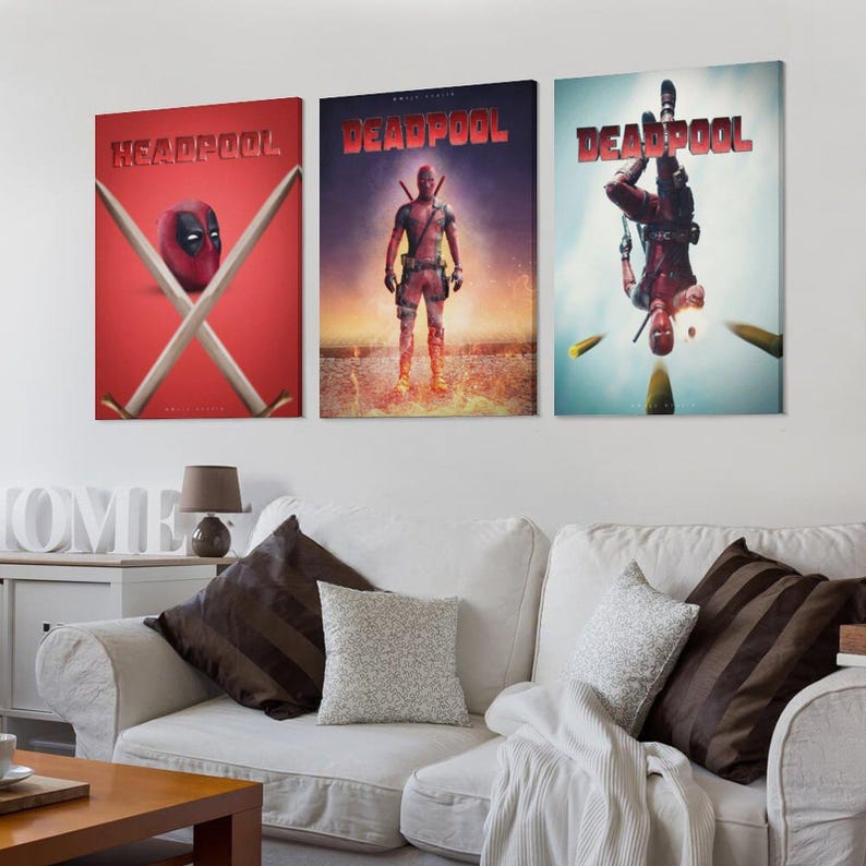 May include: Three framed canvas prints showcasing Deadpool artwork. The prints depict Deadpool in action poses, with the title "Deadpool" in red. The first print features Deadpool's mask and crossed swords on a red background.