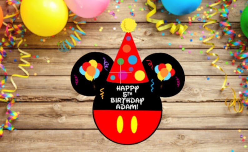 May include: A black and red mouse-shaped birthday sign featuring a red party hat with colorful polka dots, two black ears with balloon illustrations, and the white text "HAPPY 5TH BIRTHDAY ADAM!" above two yellow oval shapes on a red base.