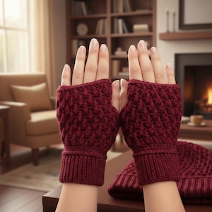 May include: Burgundy-colored fingerless gloves and a matching beanie hat. The gloves have a textured, woven pattern and ribbed cuffs. The beanie also features a ribbed design. The items are likely handmade and suitable for cold weather.