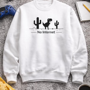 Può includere: Una tazza di ceramica bianca con un manico nero e la scritta "But First, Coffee" in nero, con un carattere a mano. La tazza è su una superficie bianca.